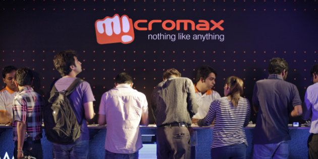 Attendees stand at a counter while looking at the Micromax Informatics Ltd. Canvas Nitro smartphone displayed during a launch event in New Delhi, India, on Monday, Sept. 8, 2014. Micromax led the Indian mobile phone market for the first time in the second quarter, accounting for 16.6 percent of shipments, compared with Samsung Electronics Co.'s 14.4 percent, Counterpoint Research said in a statement on its website. Photographer: Kuni Takahashi/Bloomberg via Getty Images