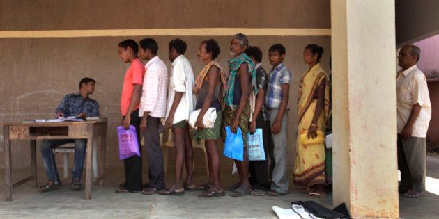 In this Wednesday, March 21, 2012 photo, Sukhbasi Mandani, 50, second from right, stands in a line with others to buy subsidized rice from a fair price shop in the Public Distribution System in Rayagada, in Indian eastern state of Orissa. India's Public Distribution System sends out 45 million metric tons of heavily subsidized food each year to help 400 million people in their tenuous struggle for survival, but in reality, the $15 billion national program is riven with corruption. But new devices are transforming Rayagada into a laboratory to test a thesis with deep implications for the future of India: Can technology fix a nation? (AP Photo/Manish Swarup)