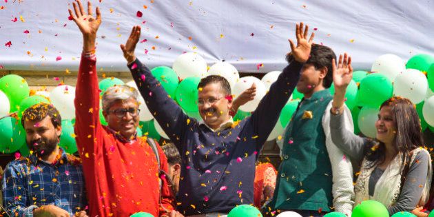 Leader of the Aam Aadmi Party, or Common Manâs Party, Arvind Kejriwal, center, waves to the crowd as his party looks set for a landslide party in New Delhi, India, Tuesday, Feb. 10, 2015. The upstart anti-corruption party appeared set to install a state government in India's capital in a huge blow for Prime Minister Narendra Modi's Hindu nationalist party. As early trends pointed to an overwhelming win for the AAP, the party's jubilant supporters began cheering and dancing in celebration, yelling