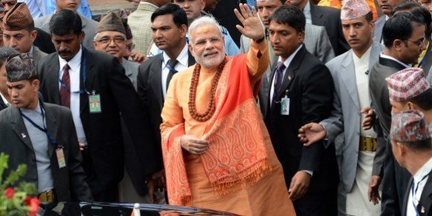 Indian Prime Minister Narendra Modi (C) waves to well-wishers as he leaves following his visit at the Pashupatinath Temple in Kathmandu on August 4, 2014. Indian Prime Minister Narendra Modi arrived in Nepal to try to speed up progress on power agreements while also aiming to counter rival giant China's influence in the region. Modi flew into Kathmandu for talks on strengthening trade ties including harnessing Nepal's vast hydropower resources in the first visit by an Indian prime minister to the Himalayan nation in 17 years. AFP PHOTO/Prakash MATHEMA (Photo credit should read PRAKASH MATHEMA/AFP/Getty Images)