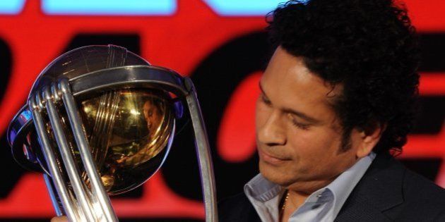 Former Indian cricketer and brand ambassador of the International Cricket Council (ICC) Cricket World Cup (CWC) 2015 Sachin Tendulkar poses for a photograph with the ICC CWC 2011 trophy during a promotional event in Mumbai on February 7, 2015. Australia and New Zealand are due to co-host the forthcoming Cricket World Cup event in which 49 matches will be played across 14 venues between February 14 - March 29. AFP PHOTO / INDRANIL MUKHERJEE (Photo credit should read INDRANIL MUKHERJEE/AFP/Getty Images)
