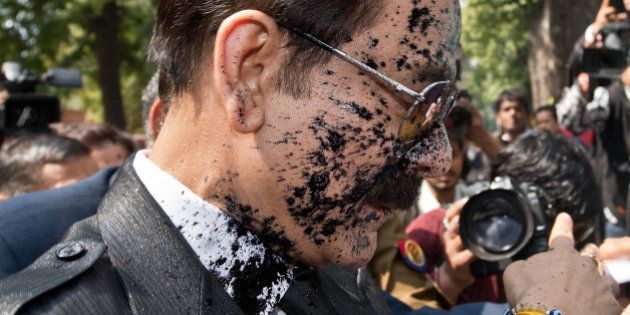 India's Sahara group chairman Subrata Roy's face is covered in black ink as he arrives at the Supreme Court in New Delhi on March 4, 2014. Ink was thrown on Sahara chairman Subrata Roy as he arrived at the Supreme Court , escorted by police personnel. The attacker, who managed to get close to Roy in the crowd and threw black ink on him, claimed to be Manoj Sharma, a lawyer from Gwalior, Madhya Pradesh. Roy was arrested after he failed to respond to the Supreme Court's summons to appear in court in connection with the case in which Sahara owes millions of investors over 22,000 crore Indian rupees (3.5 billion dollars). AFP PHOTO/Prakash SINGH (Photo credit should read PRAKASH SINGH/AFP/Getty Images)
