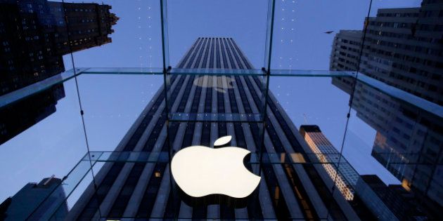 FILE - In this Sept. 5, 2014 file photo, the Apple logo hangs in the glass box entrance to the company's Fifth Avenue store, in New York. Apple, already the world's most valuable company, surpassed $700 billion in market capitalization Tuesday, Nov. 26, 2014, as its stock hit another all-time high. (AP Photo/Mark Lennihan, File)