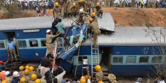 Crowds watch as Indian fire force personnel attempt to retrieve the bodies of victims from the Bangalore-Ernakulam train which derailed after a boulder fell on the track in Bidaragere, about 50 kms from Bangalore on February 13, 201. At least five passengers were killed and more than 60 injured, according to local Press Trust of India (PTI) when the Bangalore-Ernakulam Inter City Express derailed. AFP PHOTO / Manjunath KIRAN (Photo credit should read Manjunath Kiran/AFP/Getty Images)
