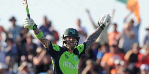 Ireland's John Mooney raises his arms after hitting the winning runs against West Indies during their Cricket World Cup pool B match at Nelson, New Zealand, Monday, Feb. 16, 2015. Ireland wins the match with 4 wickets and 25 balls to spare. (AP Photo/Ross Setford)