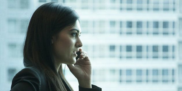 Indian businesswoman talking on cell phone in office