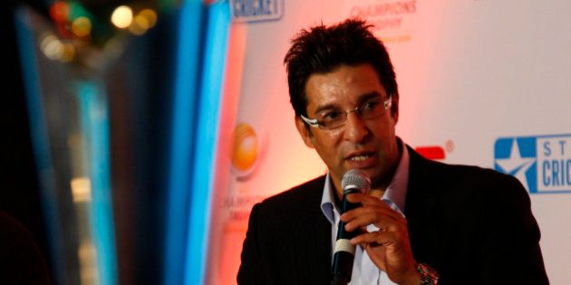 Former Pakistani cricketer Wasim Akram talks about the upcoming ICC Champions Trophy, in New Delhi, India, Thursday, Sept. 17, 2009. On the left is the trophy that will be handed out to the winner. (AP Photo/Saurabh Das)