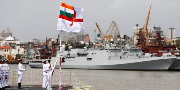 Indian naval officers hoists the navy flag during a ceremony to induct the largest indigenously built warship INS Kolkata in Mumbai, India, Saturday, Aug. 16, 2014. (AP Photo/Rajanish Kakade)