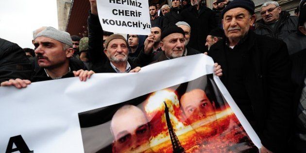 Turkish anti-Charlie Hebdo protesters hold a banner with pictures of Cherif and Said Kouachi (R), two Islamist gunmen who killed 12 people in an attack on Charlie Hebdo, during a demonstration against the depiction of the Prophet Mohammed by the French satirical weekly and mourning two Islamist gunmen who killed 12 people in an attack on Charlie Hebdo, in Istanbul on January 16, 2015. About 50 Turkish islamists gathered after friday prayer at Fatih Mosque to protest after the magazine published this week a 'survivors' issue featuring an image of the Prophet Mohammed weeping. AFP PHOTO/OZAN KOSE (Photo credit should read OZAN KOSE/AFP/Getty Images)