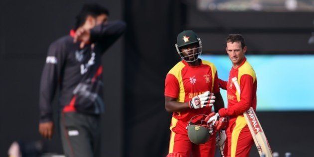 Zimbabwe batsmen Sean Williams (R) and Elton Chigumbura (2nd L) celebrate victory as United Arab Emirates (UAE) player Mohammad Naveed (L) reacts during their Pool B 2015 Cricket World Cup match in Nelson on February 19, 2015. AFP PHOTO / William WEST (Photo credit should read WILLIAM WEST/AFP/Getty Images)