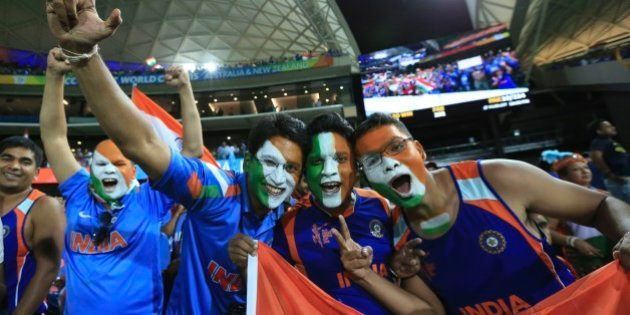 Indian cricket fans, face painted with colors of the Indian flag react to the camera after India won the World Cup Pool B match against Pakistan in Adelaide, Australia, Sunday, Feb. 15, 2015. (AP Photo/James Elsby)