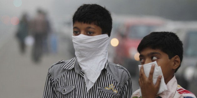 NEW DELHI, INDIA - NOVEMBER 7: Children cover their face to take precaution from the air pollution by a mixture of pollution and fog at NCR region on November 7, 2012 in New Delhi, India. (Photo by Sanjeev Verma/Hindustan Times via Getty Images)