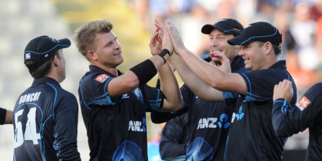 New Zealand's Corey Anderson, second from left, celebrates with teammates after dismissing Indiaâs Ajinkya Rahane for 3 in their third one day international cricket match at Eden Park in Auckland, New Zealand, Saturday, Jan. 25, 2014. (AP Photo/SNPA, Ross Setford) NEW ZEALAND OUT