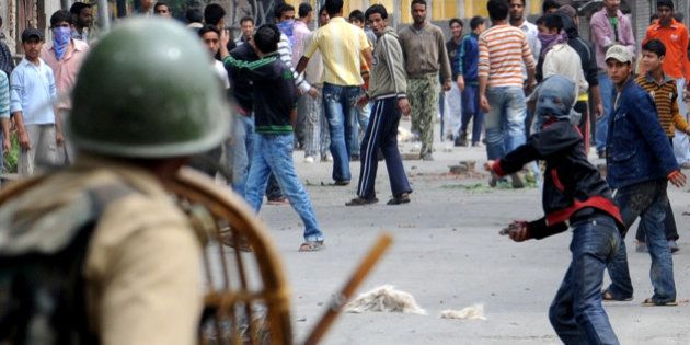 (FILES) In this photograph taken on June 12, 2010, Kashmiri protesters throw stones at Indian paramilitary soldiers during a protest in Srinagar. Indian Kashmir declared an amnesty on August 29, 2010 for more than 1,000 youths alleged to have attacked security forces during last year's pro-independence demonstrations in which more than 100 civilians died. Kashmir was rocked for months last summer by clashes between stone-throwing protesters and police and paramilitary troops, who used live fire to try to control massive rallies against New Delhi's rule over the region. AFP PHOTO/Rouf BHAT/ FILES (Photo credit should read ROUF BHAT/AFP/Getty Images)