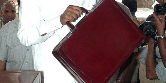 INDIA - JULY 08: Indian Finance Minister Palaniappan Chidambaram carries the briefcase containing his first budget as he enters Parliament House in New Delhi Thursday, July 8, 2004. India's new government will curb its budget deficit as a growing economy swells tax receipts, allowing it to spend more on India's 400 million poor, Chidambaram told parliament. (Photo by Sondeep Shankar/Bloomberg via Getty Images)