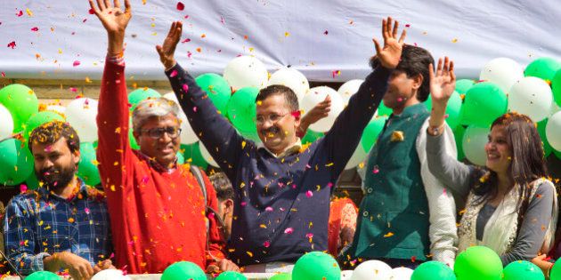Leader of the Aam Aadmi Party, or Common Manâs Party, Arvind Kejriwal, center, waves to the crowd as his party looks set for a landslide party in New Delhi, India, Tuesday, Feb. 10, 2015. The upstart anti-corruption party appeared set to install a state government in India's capital in a huge blow for Prime Minister Narendra Modi's Hindu nationalist party. As early trends pointed to an overwhelming win for the AAP, the party's jubilant supporters began cheering and dancing in celebration, yelling