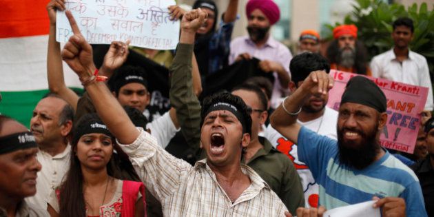 Indians shout slogans seeking death sentence for a juvenile convict who was earlier given a three-year in a reform home, after a judge pronounced death sentence for four others convicted in the rape and murder of a student on a moving New Delhi bus last year, in New Delhi, India, Friday, Sept. 13, 2013. The case has been closely followed across India, seen as a reflection on rampant mistreatment of women and the government's inability to deal with crime. (AP Photo/Altaf Qadri)