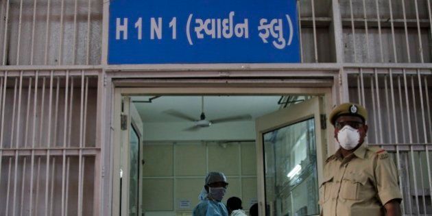 A security man stands outside an isolation ward for swine flu at the Civil Hospital in Ahmadabad, India, Wednesday, Feb. 25, 2015.The west Indian city has banned large public gatherings in an attempt to halt the spread of swine flu, which has claimed more than 900 lives nationwide in 11 weeks. Gujarati reads,