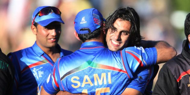 Afghanistanâs Shapoor Zadran, right, embraces teammate Samiullah Shenwari as he celebrates his team's Cricket World Cup Pool A win over Scotland in Dunedin, New Zealand, Thursday, Feb. 26, 2015. (AP Photo/Dianne Manson)