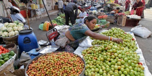 An Indian woman sells berries at a wayside vegetable market in Ahmadabad, India, Monday, Feb. 23, 2015. The government of Asia's third-largest economy is this week expected to present in Parliament the budget for the fiscal year ending March 2016. (AP Photo/Ajit Solanki)