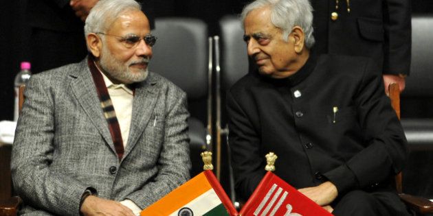 JAMMU, INDIA - MARCH 1: Prime Minister Narendra Modi along with Chief Minister Mufti Mohammad Sayeed during an oath ceremony of Mufti Mohammad Sayeed as the chief minister Of Jammu and Kashmir, on March 1, 2015 in Jammu, India. Sayeed said that he felt proud that the people in the heart of Srinagar city came out in large number to vote and thanked the 'people from across the border' for the 'conducive atmosphere' for the smooth conduct of the elections. (Photo by Nitin Kanotra/Hindustan Times via Getty Images)