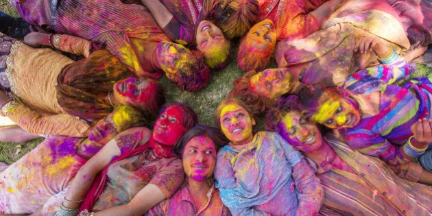 Young Indian people celebrating the Hindu festival of Holi by throwing coloured powder called Gulal at each other
