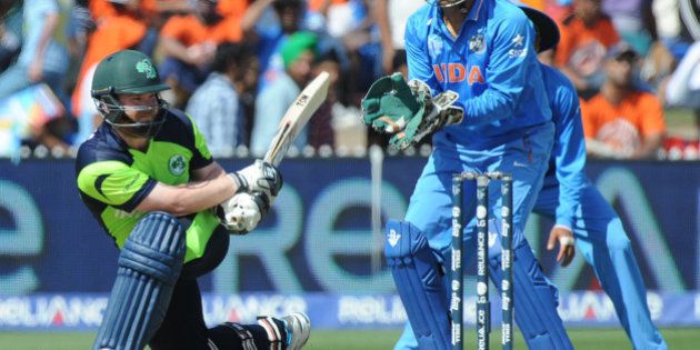 Ireland's Paul Stirling plays a sweep shot as India's wicketkeeper MS Dhoni watches during their Cricket World Cup Pool B match in Hamilton, New Zealand, Tuesday, March 10, 2015. (AP Photo/Ross Setford)