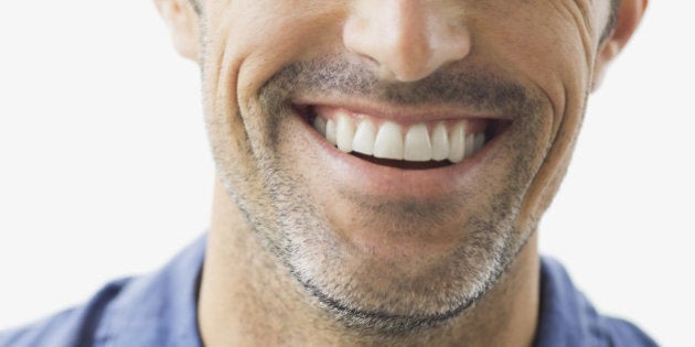 Close-up portrait of smiling man against white background