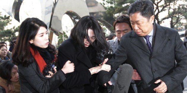 Cho Hyun-ah, center, former vice president of Korean Air Lines, arrives at the Seoul Western District Prosecutors Office in Seoul, South Korea, Tuesday, Dec. 30, 2014. A Seoul court is expected to decide Tuesday whether to issue an arrest warrant for Cho, who resigned as vice president at the airline earlier this month amid mounting public criticism over the incident that she forced a flight to return over a bag of macadamia nuts and a current executive for attempts to cover up the
