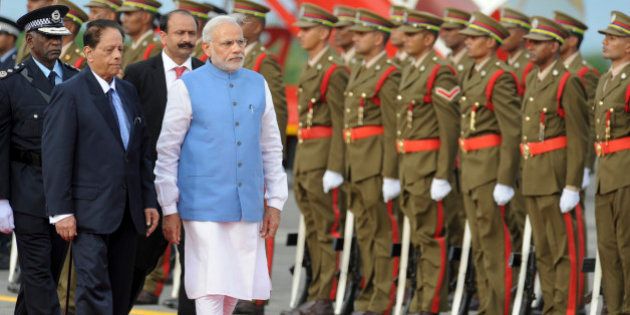 India's Prime Minister Narendra Modi, center-left, inspects an honour guard accompanied by Prime Minister of Mauritius Anerood Jugnauth, left, upon his arrival at the airport on Mauritius Island, in the Republic of Mauritius Wednesday, March 11, 2015. According to the Indian Prime Minister's website Modi is leading a delegation on a three nation tour of Seychelles, Mauritius and Sri Lanka to strengthen ties between the countries. (AP Photo/George Michel)