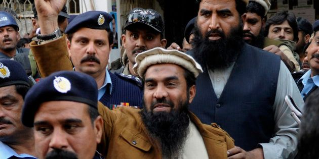 Zaki-ur-Rahman Lakhvi, the main suspect of the Mumbai terror attacks in 2008, raises his fist after his court appearance in Islamabad, Pakistan, Thursday, Jan. 1, 2015. Lakhvi was sent to judicial remand in an abduction case by a court, official said. (AP Photo/B.K. Bangash)