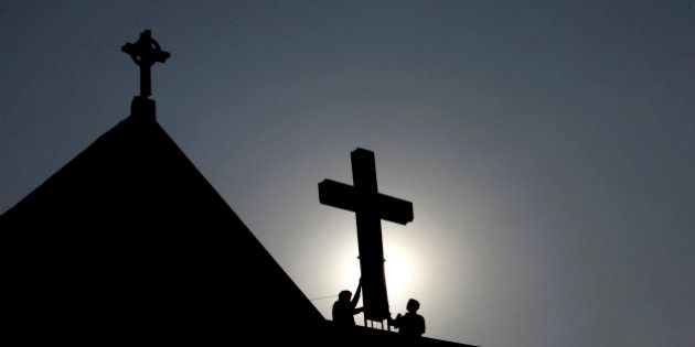 Indian workers paint a cross atop a church ahead of Christmas in Hyderabad, India, Monday, Dec. 19, 2011. Christians make up about 2 percent of India's 1 billion-plus population. (AP Photo/Mahesh Kumar A.)