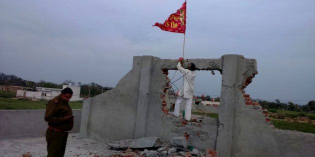 HISAR, INDIA - MARCH 16: A red flag hoisted on an under construction church that was vandalized by some miscreants at village Kaimri on March 16, 2015 in Hisar, India. The under-construction site was vandalized by some miscreants and idol of a Hindu god was placed inside its premises on March 13. Police has booked 14 people for rioting, damaging place of worship, theft and promoting enmity on complaint by the church priest. Tension prevails in the area with the villagers demanding that cases be withdrawn against those among the booked with no hand in the incident. (Photo by Manoj Dhaka/Hindustan Times via Getty Images)