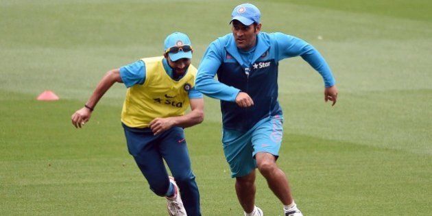 Indian cricket captain Mahendra Singh Dhoni (R) dribbles the ball past teammate Ajinkya Rahane (L) in a game of football during a training session ahead of their 2015 Cricket World Cup quarter-final match against Bangladesh, in Melbourne on March 17, 2015. AFP PHOTO / William WEST --IMAGE RESTRICTED TO EDITORIAL USE - STRICTLY NO COMMERCIAL USE-- (Photo credit should read WILLIAM WEST/AFP/Getty Images)