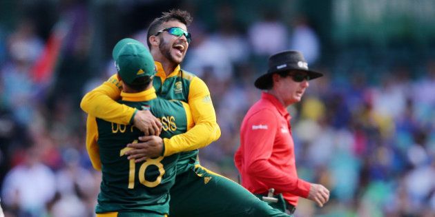 South Africa's JP Duminy, right, is congratulated by teammate Francois Du Plessis after taking the wicket of Sri Lanka's Angelo Mathews during their Cricket World Cup quarterfinal match in Sydney, Australia, Wednesday, March 18, 2015.(AP Photo/Rob Griffith)
