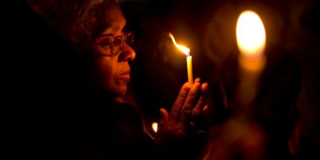 A Christian woman prays as they hold a candle light vigil to condemn the gang rape of a nun at a Christian missionary school in eastern India outside the Sacred Heart cathedral in New Delhi, India, Monday, March 16, 2015. According to police a nun in her 70s was gang-raped by a group of bandits when she tried to prevent them from committing a robbery in the Convent of Jesus and Mary School in West Bengal state's Nadia district. The attack early Saturday is the latest crime to focus attention on the scourge of sexual violence in India. (AP Photo/Saurabh Das)
