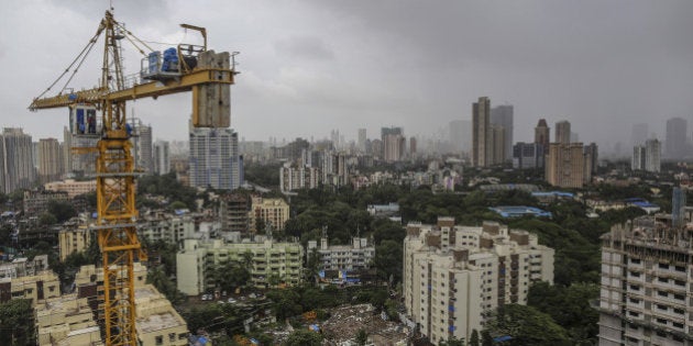 A tower crane operates at a residential construction site, developed by Omkar Realtors & Developers Pvt., in the Parel area of Mumbai, India, on Friday, Aug. 8, 2014. Omkar is playing an important role in Mumbais plan to do something about its enormous and embarrassing problem: at least 6.5 million slum dwellers, still living without running water, private toilets or the basics of sanitation. Omkar's Cresent Bay development consists of six luxury towers with million-dollar apartments overlooking the Arabian Sea, coupled with housing blocks nearby with free homes for all the slum dwellers with rights to the land. Photographer: Dhiraj Singh/Bloomberg via Getty Images