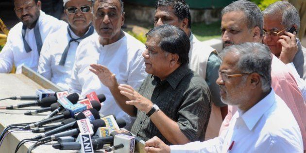 Indian leaders and members of the opposition in the Karnataka State Legislative Assembly, gather outside the Raj Bhavan after submitting a memorandum to the State Governor urging him to pressurise the Congress-ruled state government to hand over the inquiry into the controversial death of a popular Indian Administrative Service (IAS) Officer, D.K. Ravi to the Central Bureau of Investigation (CBI), in Bangalore on March 19, 2015. Additional commissioner of commercial taxes (Enforcement), Ravi (35) was found hanging from a ceiling fan of his flat in Bangalore on March 16, with police suspecting it to be prima facie a case of suicide. AFP PHOTO / Manjunath KIRAN (Photo credit should read Manjunath Kiran/AFP/Getty Images)