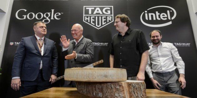 (L TO R) Swiss watchmaker Tag Heuer Director General Guy Semon, Tag Heuer CEO Jean-Claude Biver, Intel's new device general manager Michael Bell and Google's engineering director for Android wear David Singleton pose with a Swiss cheese during the anoucement on March 19, 2015 in Basel of a partnership between the watch brand, owned by the French luxury group LVMH and the two giants of the Silicon Valley. Luxury Swiss watchmaker Tag Heuer announced it was joining forces with technology behemoths Google and Intel to develop a connected timepiece that can compete with the new Apple Watch.AFP PHOTO / FABRICE COFFRINI (Photo credit should read FABRICE COFFRINI/AFP/Getty Images)