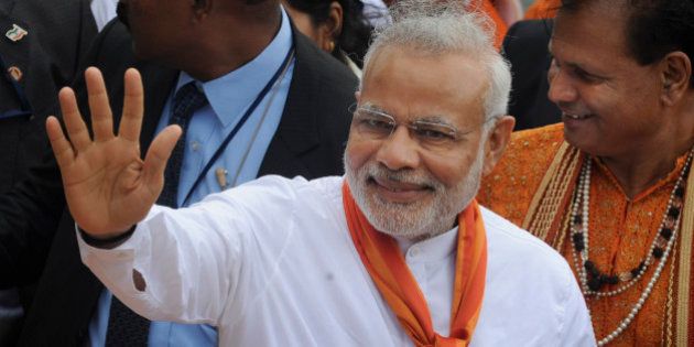 India's Prime Minister Narendra Modi waves during a visit to the crater lake of Grand Bassin (also known as Ganga Talao) during the second day of his visit to the Republic of Mauritius Thursday, March 12, 2015. According to the Indian Prime Minister's website Modi is leading a delegation on a three nation tour of Seychelles, Mauritius and Sri Lanka to strengthen ties between the countries. (AP Photo/George Michel)
