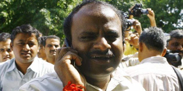 Chief Minister of the Indian state of Karnataka H.D. Kumaraswamy (C) speaks on a cellular telephone while leaving a meeting in New Delhi, 06 October 2007, enroute for Bangalore. Karnataka is set to witness the collapse of its second coalition government in a span of 20 months and prospects of mid-term assembly polls with the 'betrayed' BJP deciding to withdraw support to the H D Kumaraswamy government after the JDS denied power transfer to it. The abrupt end to the 20-month-old marriage between JDS and BJP after they cobbled up a surprise alliance to rule the state was expected in the wake of escalating strains in their relations and JD(S) sending clear signals that it was not for handing over the baton to the saffron party on October three as agreed earlier. AFP PHOTO/ Manpreet ROMANA (Photo credit should read MANPREET ROMANA/AFP/Getty Images)