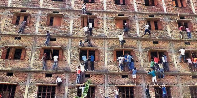 CAPTION CORRECTS THE YEAR - FILE - In this Wednesday, March 18, 2015 file photo, Indians climb the wall of a building to help students appearing in an examination in Hajipur, in the eastern Indian state of Bihar. Education authorities in eastern India say 600 high school students have been expelled after they were found to have cheated on pressure-packed 10th grade examinations. (AP Photo/Press Trust of India, File) INDIA OUT