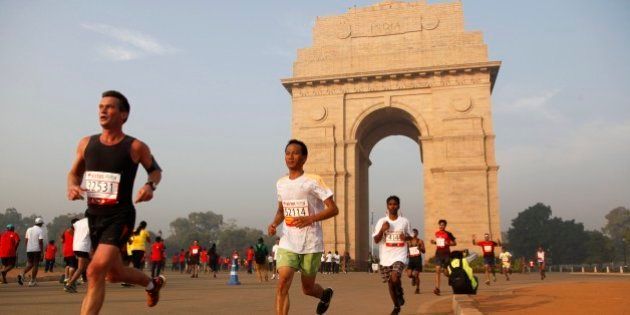 Participants of Delhi Half Marathon run past the India Gate war memorial in New Delhi, India, Sunday, Nov. 23, 2014. (AP Photo/Tsering Topgyal)