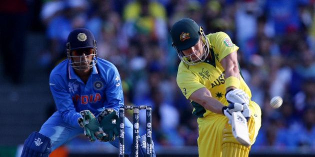Australia's Shane Watson hits the ball for six runs as India's MS Dhoni watches during their Cricket World Cup semifinal in Sydney, Australia, Thursday, March 26, 2015. (AP Photo/Rob Griffith)