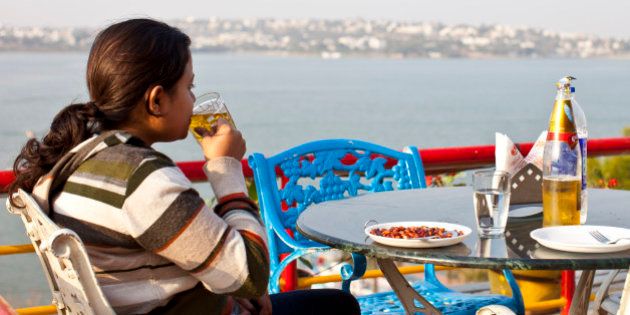 BHOPAL, MADHYA PRADESH, INDIA - FEBRUARY 01: A young Indian woman drinks beer at a terrace with panoramic view of Lake Bhopal on February 1, 2012 in Bhopal, Madhya Pradesh, India (Photo by EyesWideOpen/Getty Images)