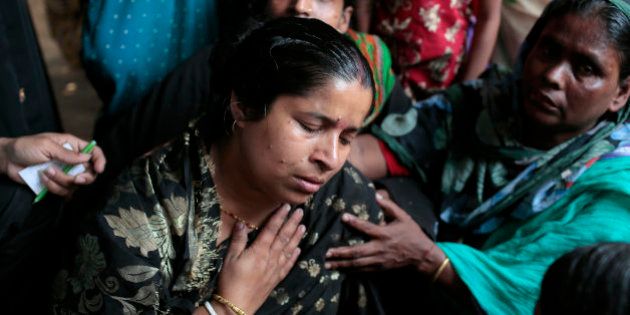 A Bangladeshi Hindu devotee Dipali Das cries as she sits next to the body of a relative who was killed in a stampede during a Hindu bathing ritual in Langalbandh, 20 kilometers (12 miles) southeast of capital Dhaka, Bangladesh, Friday, March 27, 2015. Local police chief Nazrul Islam said the stampede took place in a Hindu pilgrimage spot on the banks of the Brahmaputra river during an annual religious bathing ritual. (AP Photo/ A.M. Ahad)