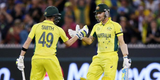 Australian captain Michael Clarke, right, is congratulated by teammate Steve Smith after scoring 50 runs while batting against New Zealand during the Cricket World Cup final in Melbourne, Australia, Sunday, March 29, 2015. (AP Photo/Rick Rycroft)