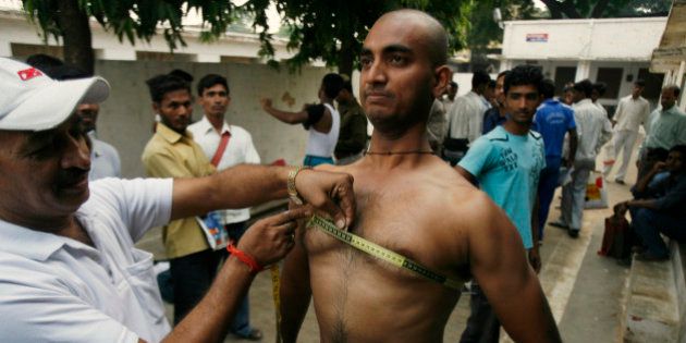 A candidate gets his chest measured as part of a fitness test during recruitment for Uttar Pradesh state police in Allahabad, India, Thursday, Nov. 12, 2009. The state wide recruitment process to fill 35,000 police constable posts started Thursday. (AP Photo/Rajesh Kumar Singh)