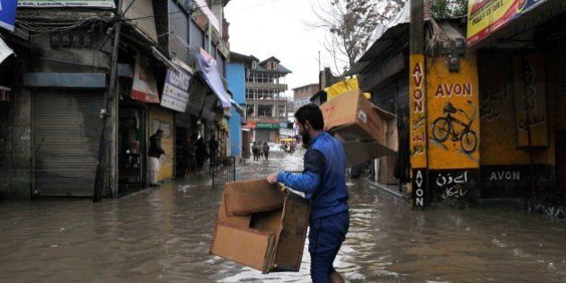 SRINAGAR, INDIA - MARCH 29: Shopkeepers shift merchandise to safer places in wake of accumulation of water in the streets and market places during rain on March 29, 2015 in Srinagar, India. Intermittent rainfall across Kashmir raised water level of streams and rivers, triggering panic among resident of floods. The valley has been witnessing heavy rainfall since Saturday, leading to a sudden surge in water level in rivers, streams and rivulets. The Met Department has predicted more rain over the next six days with heavy rain expected today and on April 3. (Photo by Waseem Andrabi/Hindustan Times via Getty Images)