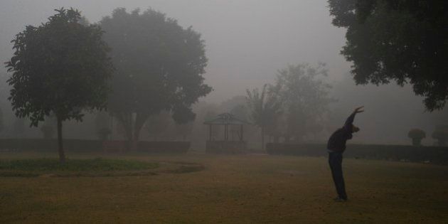 An Indian man exercises in a park on a cold foggy morning in New Delhi, India, Wednesday, Dec. 24, 2014. Cold wave conditions continues unabated in the northern region with fog enveloping most areas and affecting transport services. (AP Photo/Saurabh Das)